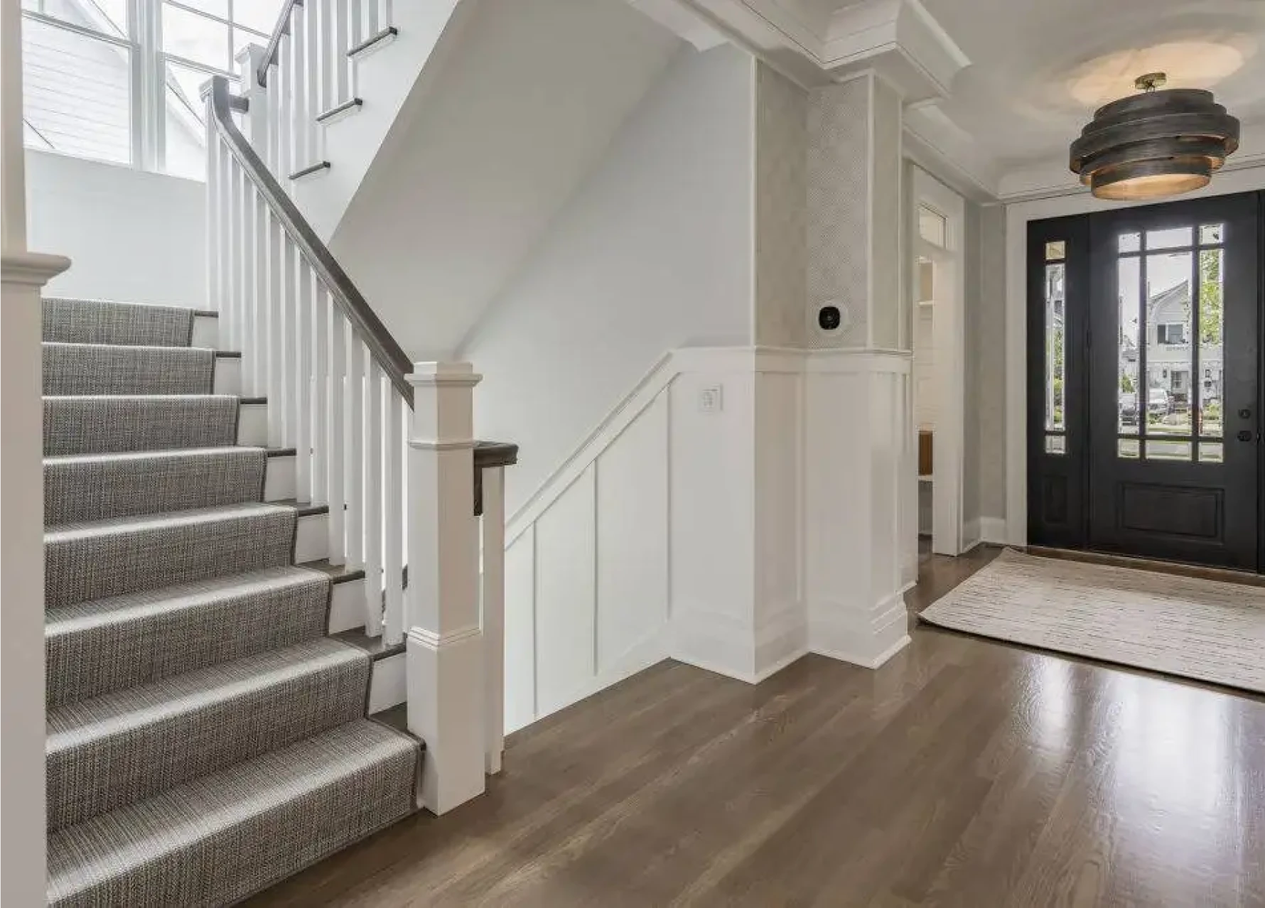 Bright entryway featuring stairs and wooden floor.